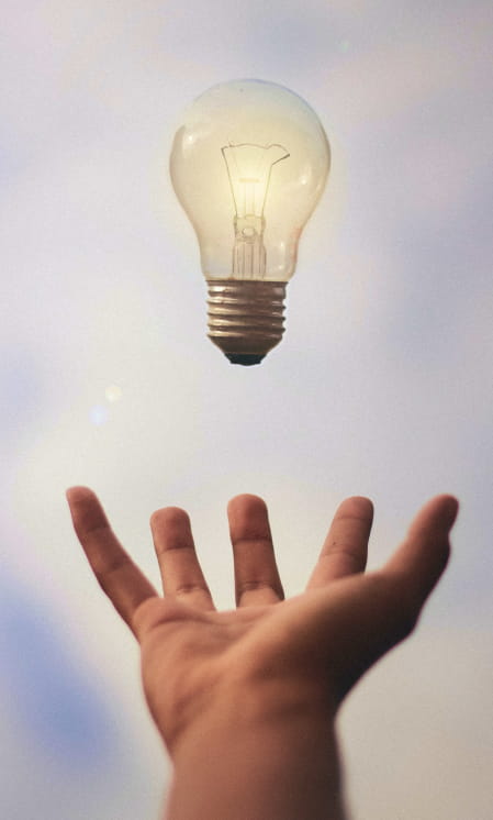 outstretched hand with lightbulb hovering above